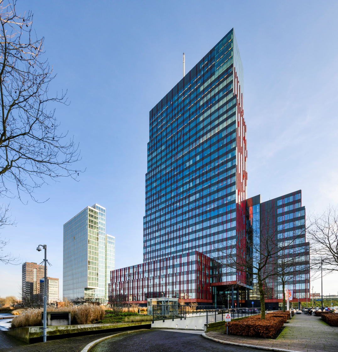 Modern kantoorpand aan de P.J. Oudweg in Almere, met hoge glazen gevel en opvallende rood-zwarte accenten.
